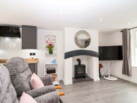 A living room with a fireplace and television at Lilly's Cottage in Dawlish