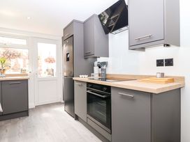 A kitchen with cabinets and appliances at Lilly's Cottage Dawlish