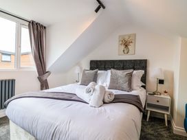 A bedroom with a bed and curtains at Lilly's Cottage Dawlish