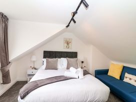 A bedroom with a bed and a sofa at Lilly's Cottage Dawlish