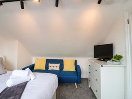 A bedroom with a bed and sofa at Lilly's Cottage Dawlish