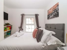 A bedroom with a bed and window at Lilly's Cottage in Dawlish