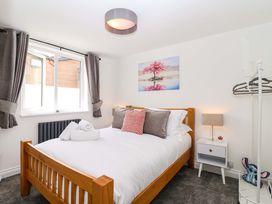 A bedroom with a bed and window at Lilly's Cottage in Dawlish
