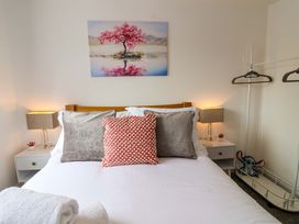 A bedroom with a bed and artwork at Lilly's Cottage Dawlish