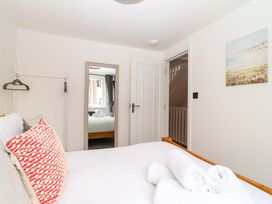 A bedroom with a bed and mirror at Lilly's Cottage in Dawlish