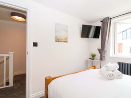 A bedroom with a bed and television at Lilly's Cottage in Dawlish