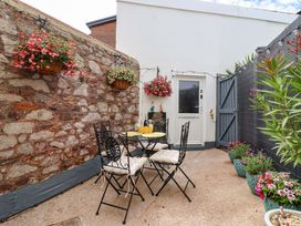 A garden with a table and chairs at Lilly's Cottage in Dawlish