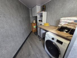 A laundry room with a washing machine and storage at Lilly's Cottage in Dawlish