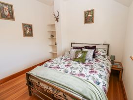 A bedroom with a floral bedspread and animal-themed cushions and artwork at Rayson Hall Barns in Ousby