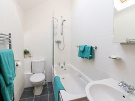 A bathroom with a toilet bathtub with shower and sink at Rayson Hall Barns in Ousby