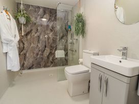 A bathroom with shower, toilet, sink and towel at Mount House Bryniau near Dyserth