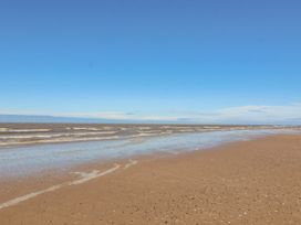 A beach with waves and sand at Mount House Bryniau near Dyserth