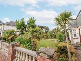 An outdoor area with palm trees and a lawn at Mount House Bryniau near Dyserth