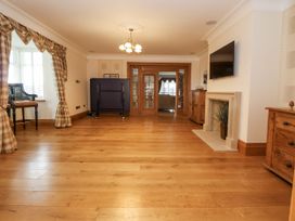 A living room with wooden flooring and a television at Mount House Bryniau near Dyserth