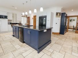 A kitchen with an island and refrigerator at Mount House Bryniau near Dyserth