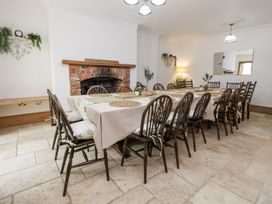 A dining room with a long table and chairs at Mount House Bryniau near Dyserth