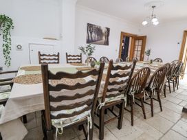 A dining room with a long table and chairs at Mount House in Bryniau near Dyserth