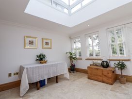 A conservatory with a table and plants at Mount House Bryniau near Dyserth