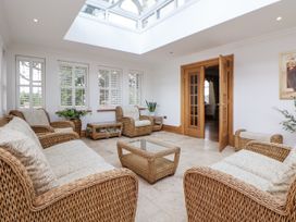 A conservatory with seating and plants at Mount House in Bryniau near Dyserth