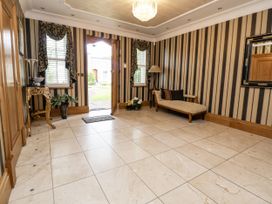 A hallway with a sofa, table, and plants at Mount House Bryniau near Dyserth