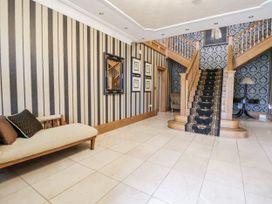 A hallway with a staircase and a sofa at Mount House Bryniau near Dyserth