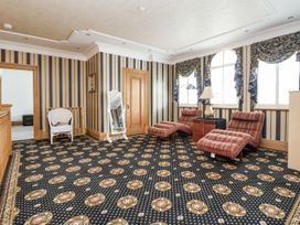 A sitting room with chairs and a lamp at Mount House in Bryniau near Dyserth