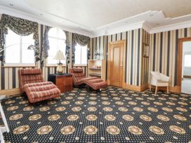 A sitting room with recliner chairs and a lamp at Mount House Bryniau near Dyserth