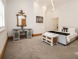 A bedroom with a bed and a dresser at Mount House Bryniau near Dyserth