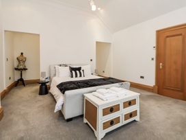 A bedroom with a bed and towels on a dresser at Mount House in Bryniau near Dyserth