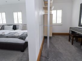 A bedroom with a bed and a wardrobe at Mount House Bryniau near Dyserth