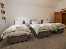 A bedroom with three beds at Mount House Bryniau near Dyserth
