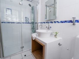 A bathroom with a shower and wash basin at Mount House Bryniau near Dyserth