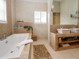 A bathroom with a bathtub and double sinks at Mount House in Bryniau near Dyserth