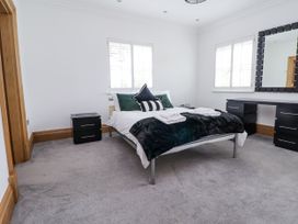A bedroom with a bed and nightstand at Mount House Bryniau near Dyserth
