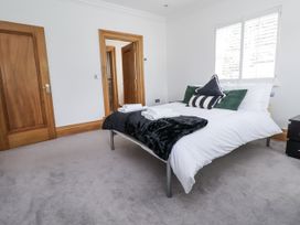 A bedroom with a bed and nightstand at Mount House Bryniau near Dyserth