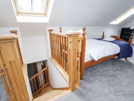 A bedroom with a bed and stairs at Mount House Bryniau near Dyserth