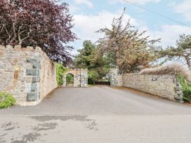 An entrance with a stone wall and gate at Mount House Bryniau near Dyserth