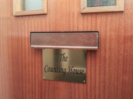 A wooden door with a mail slot and a plaque that reads The Counting House
