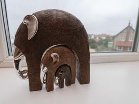 Three nested decorative elephant sculptures on a window sill at Counting House in Bridlington