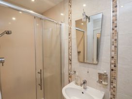 A bathroom with a shower enclosure and a sink with a mirror above it at Counting House in Bridlington