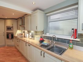 A kitchen with a sink dish rack microwave oven and countertop items at Secret Garden in Bridlington