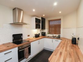 A kitchen with wooden countertops white cabinets and black appliances at Lookout Post in Bridlington