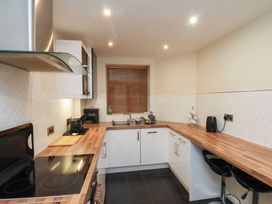 A kitchen with wooden countertops white cabinets and black appliances at Lookout Post in Bridlington