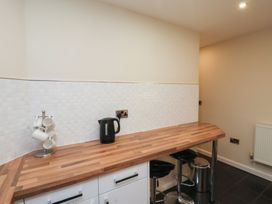 A kitchen counter with a kettle and mug stand next to bar stools at Lookout Post in Bridlington