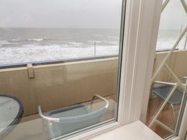 A balcony with metal chairs and a round glass table overlooking the sea at Lookout Post in Bridlington