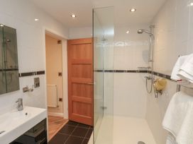 A bathroom with a sink a glass shower screen and towels hanging on a rack at Lookout Post in Bridlington