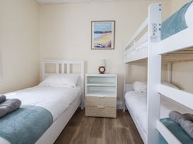 A bedroom with a single bed and bunk bed at Sea Ledge in Tintagel