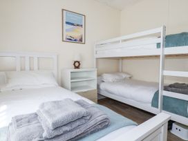 A bedroom with a bunk bed and a single bed at Sea Ledge in Tintagel