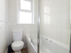 A bathroom with a toilet and bath at Sea Ledge in Tintagel