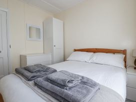 A bedroom with a bed and towels at Sea Ledge in Tintagel